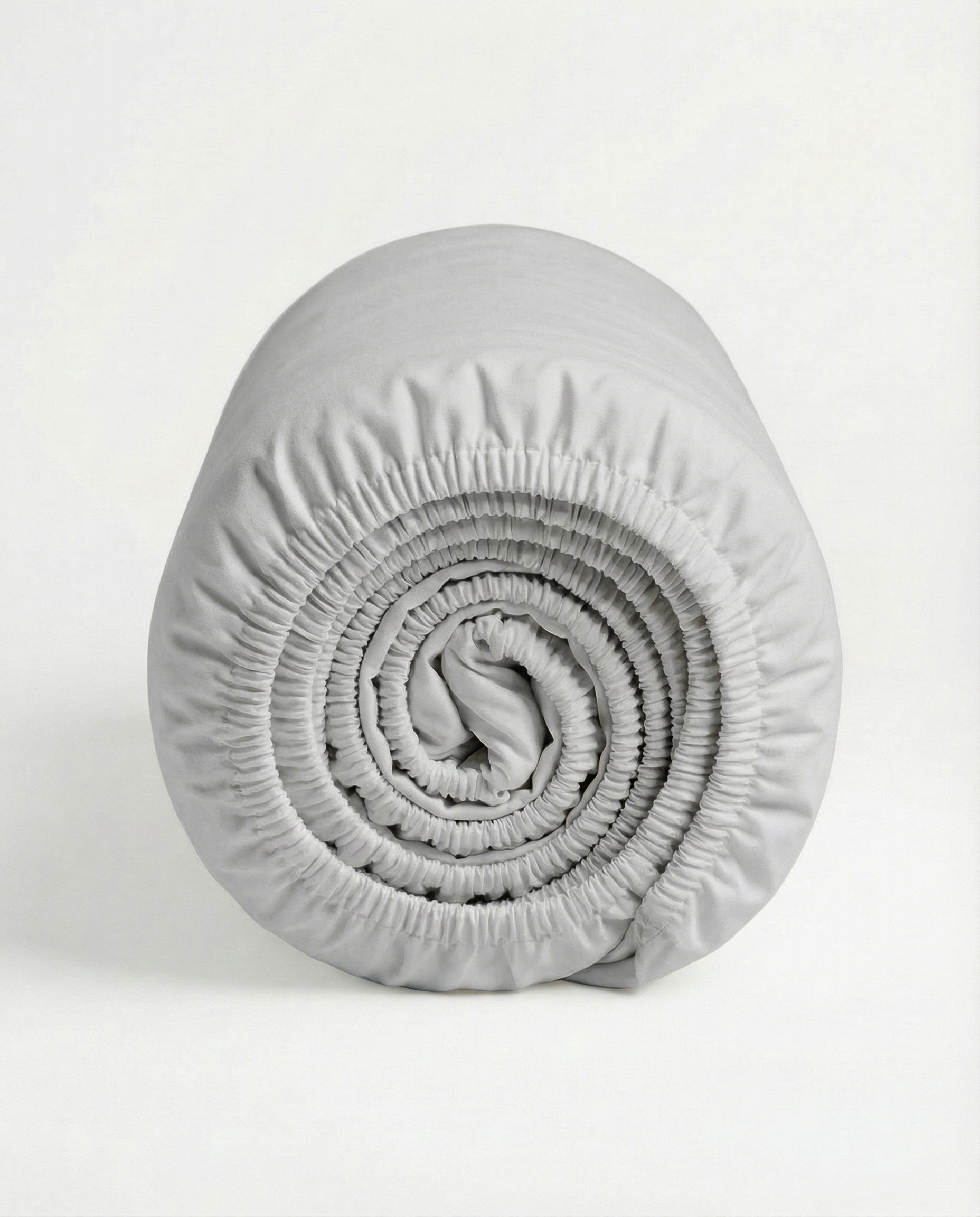 Rolled light grey fitted sheet with smooth Tencel sateen fabric and elastic edge.