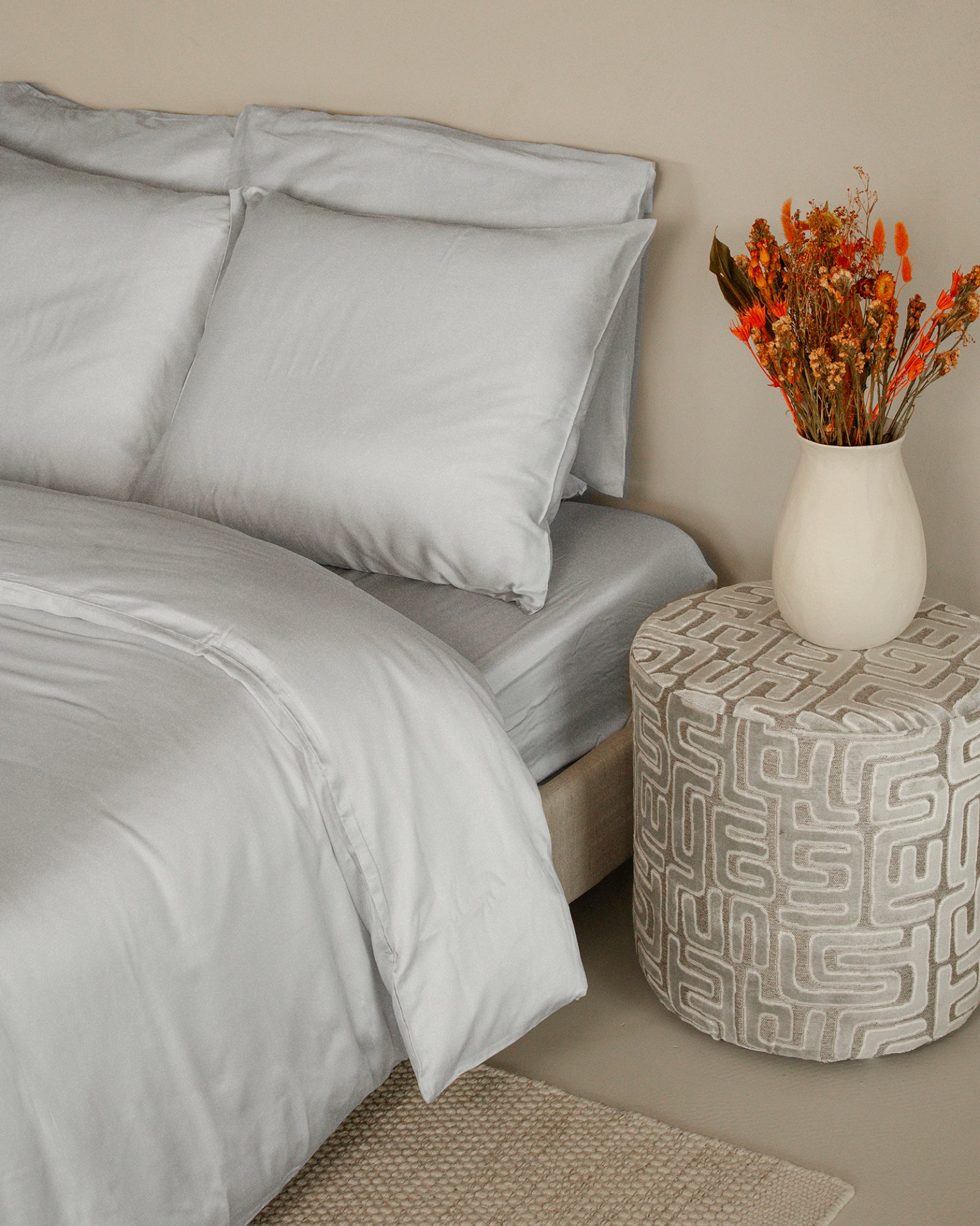 Luxury Tencel™ sateen duvet cover set in calm grey with smooth, silky texture and matching pillowcases on bed.