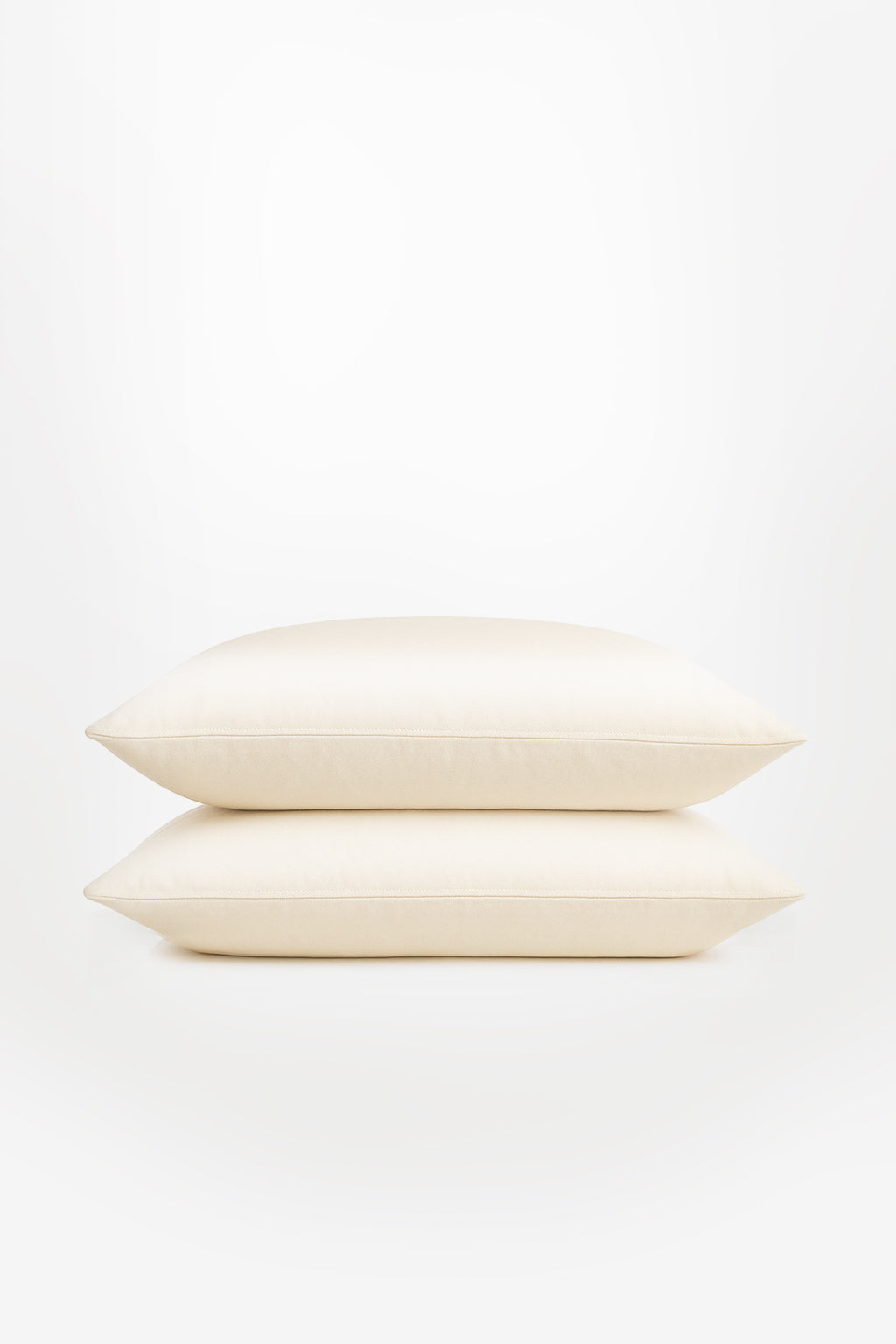 Two classic ivory Tencel™ sateen pillowcases stacked on a white background with smooth texture and subtle sheen.