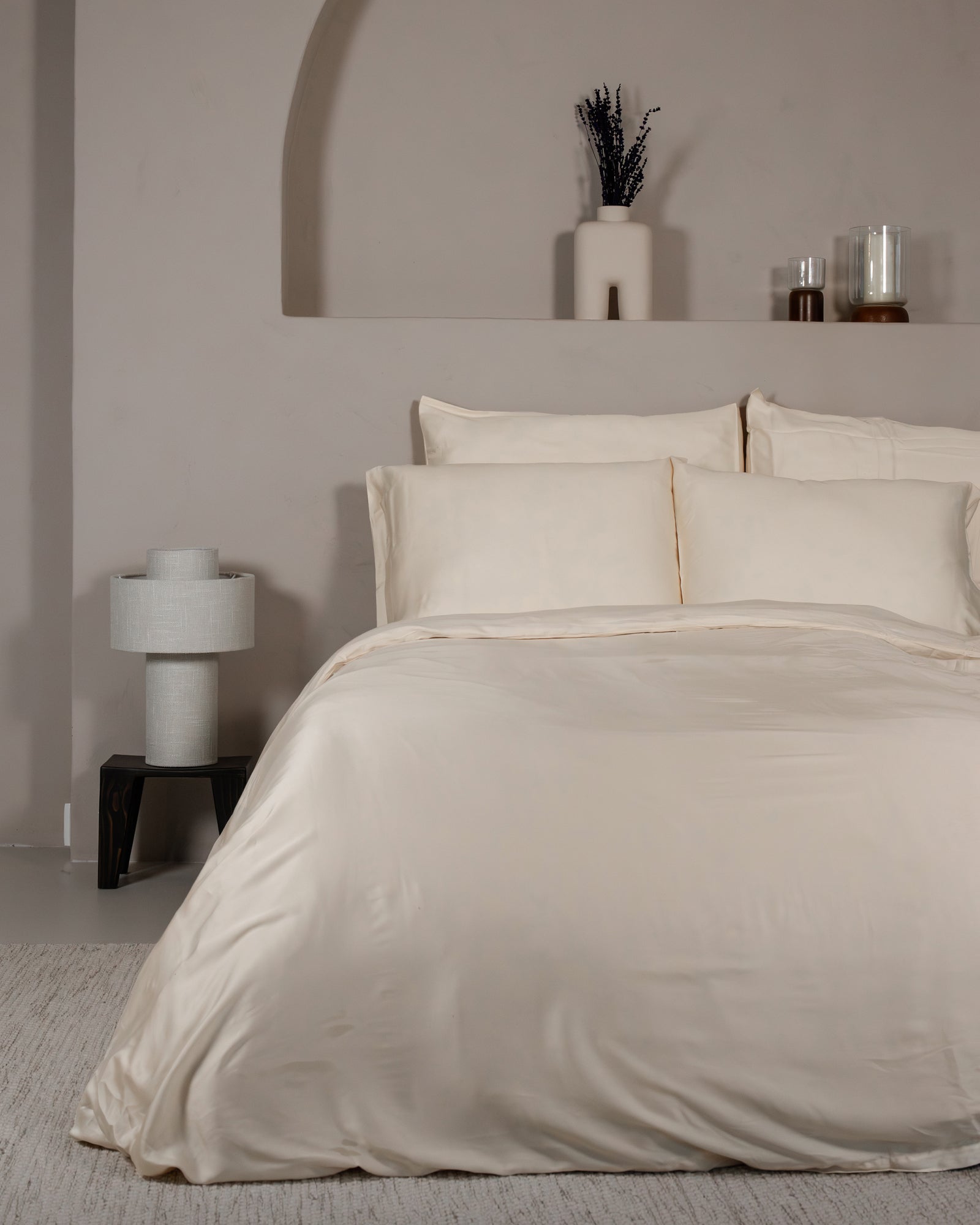 Classic ivory Tencel sateen duvet cover set with pillowcases on a bed in a minimalist bedroom.