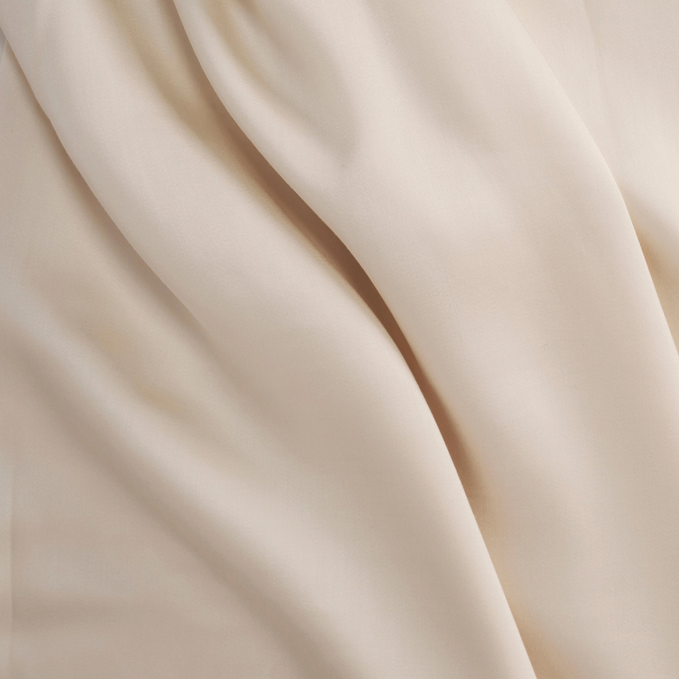 Soft, smooth Classic Ivory Tencel™ sateen pillowcase fabric with subtle folds.
