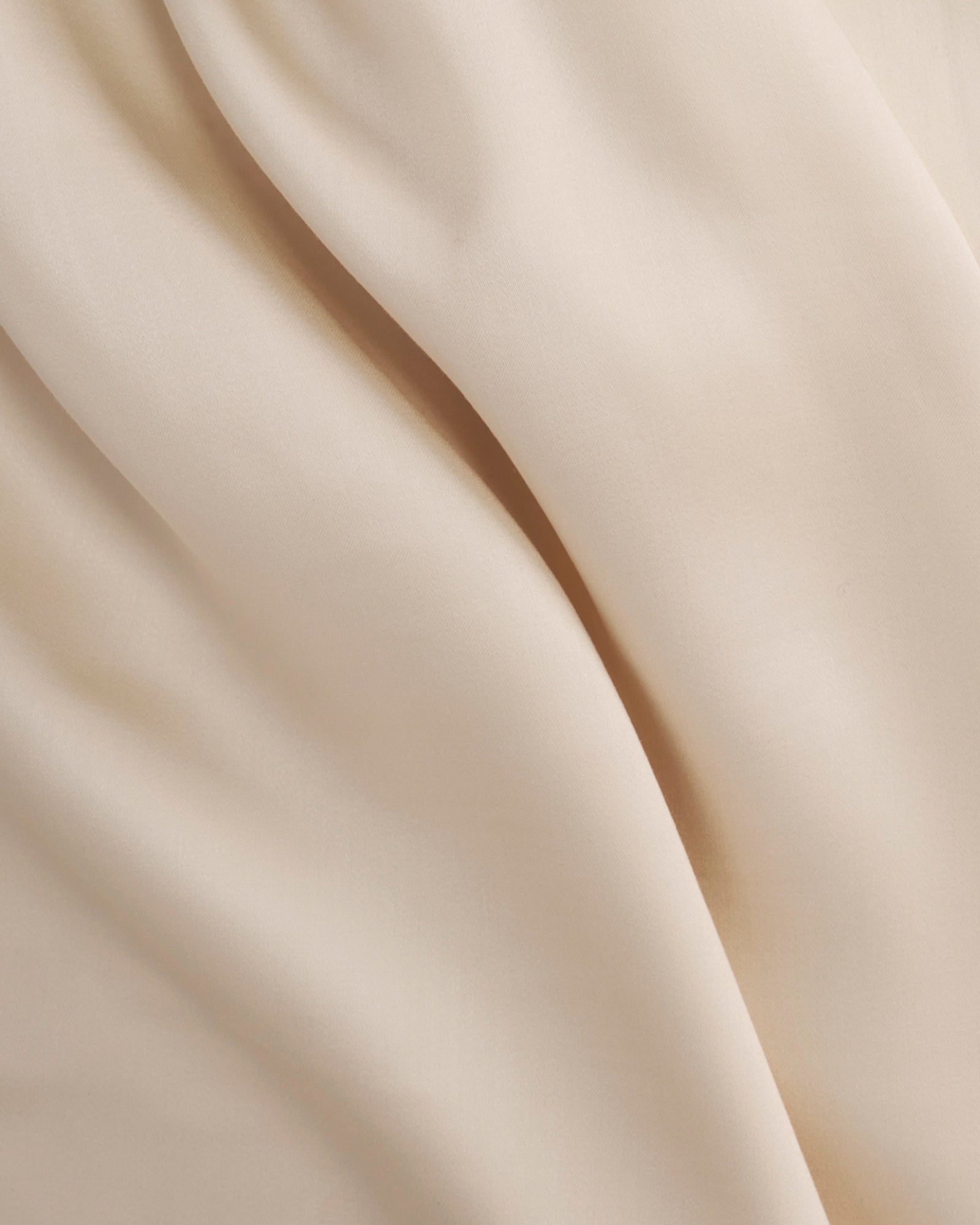Smooth ivory Tencel™ sateen duvet cover fabric with subtle sheen and soft drape.