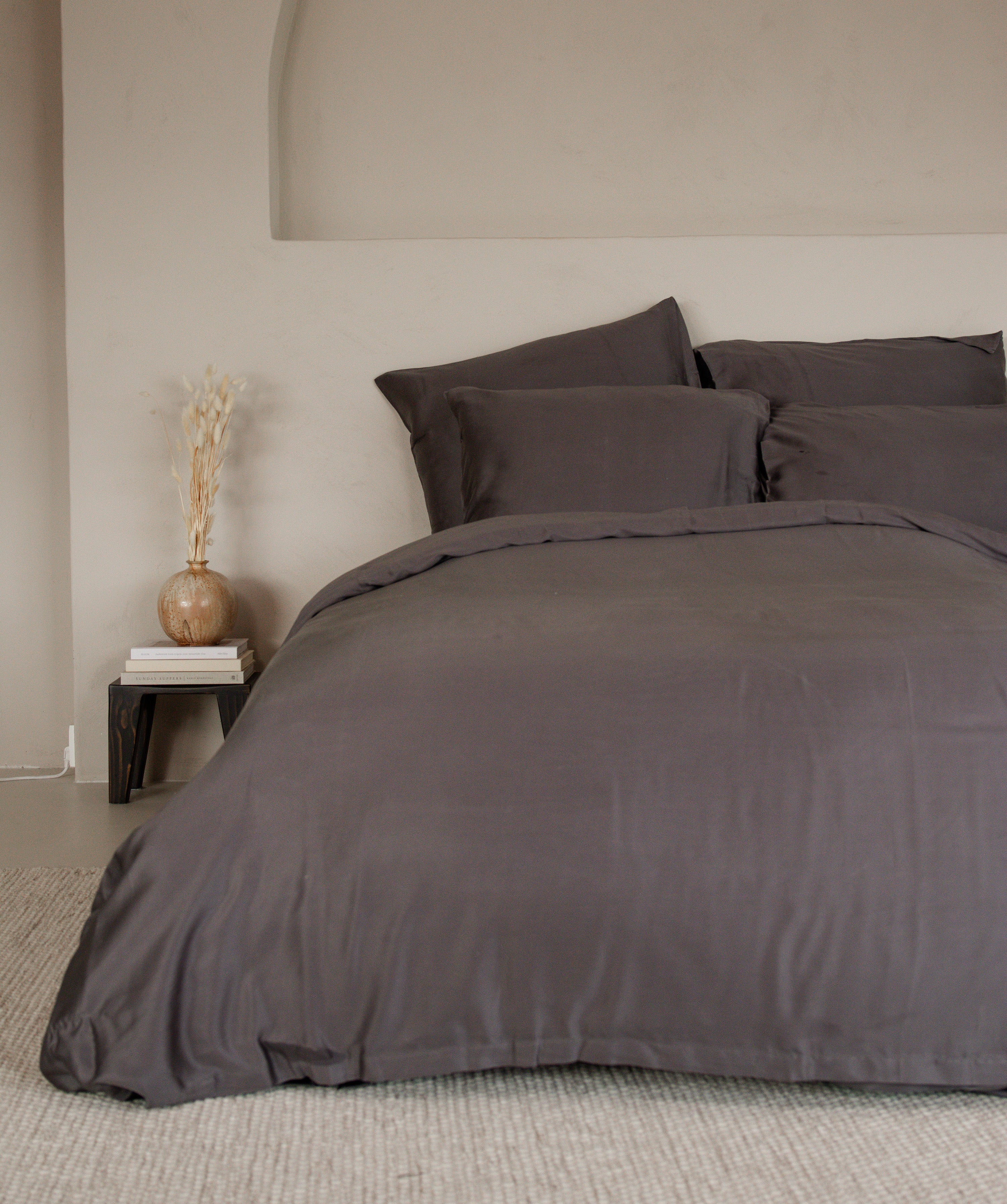 Calm Grey Tencel™ sateen flat sheet and matching pillowcases styled on bed with neutral decor background.