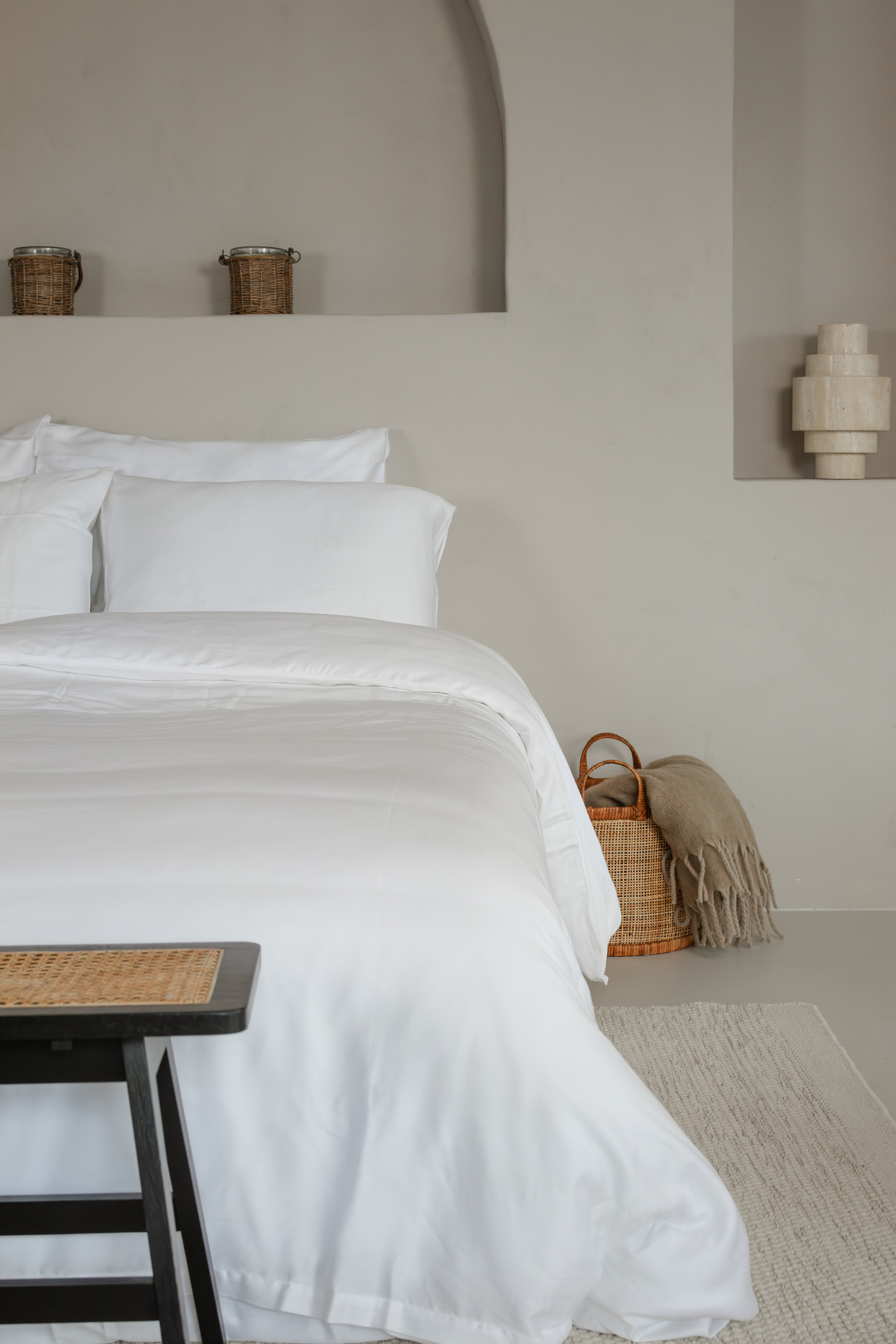 Luxurious white Tencel™ sateen pillowcases on a neatly made bed with matching duvet in a minimalist bedroom.